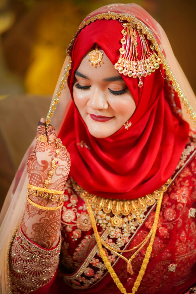 Beautiful South Asian bride wearing traditional red bridal attire and intricate jewelry.